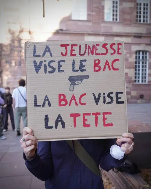 Pancarte en carton, avec le dessin d’un pistolet&nbsp;: «&nbsp;La jeunesse vise le bac, la BAC vise la tête&nbsp;»